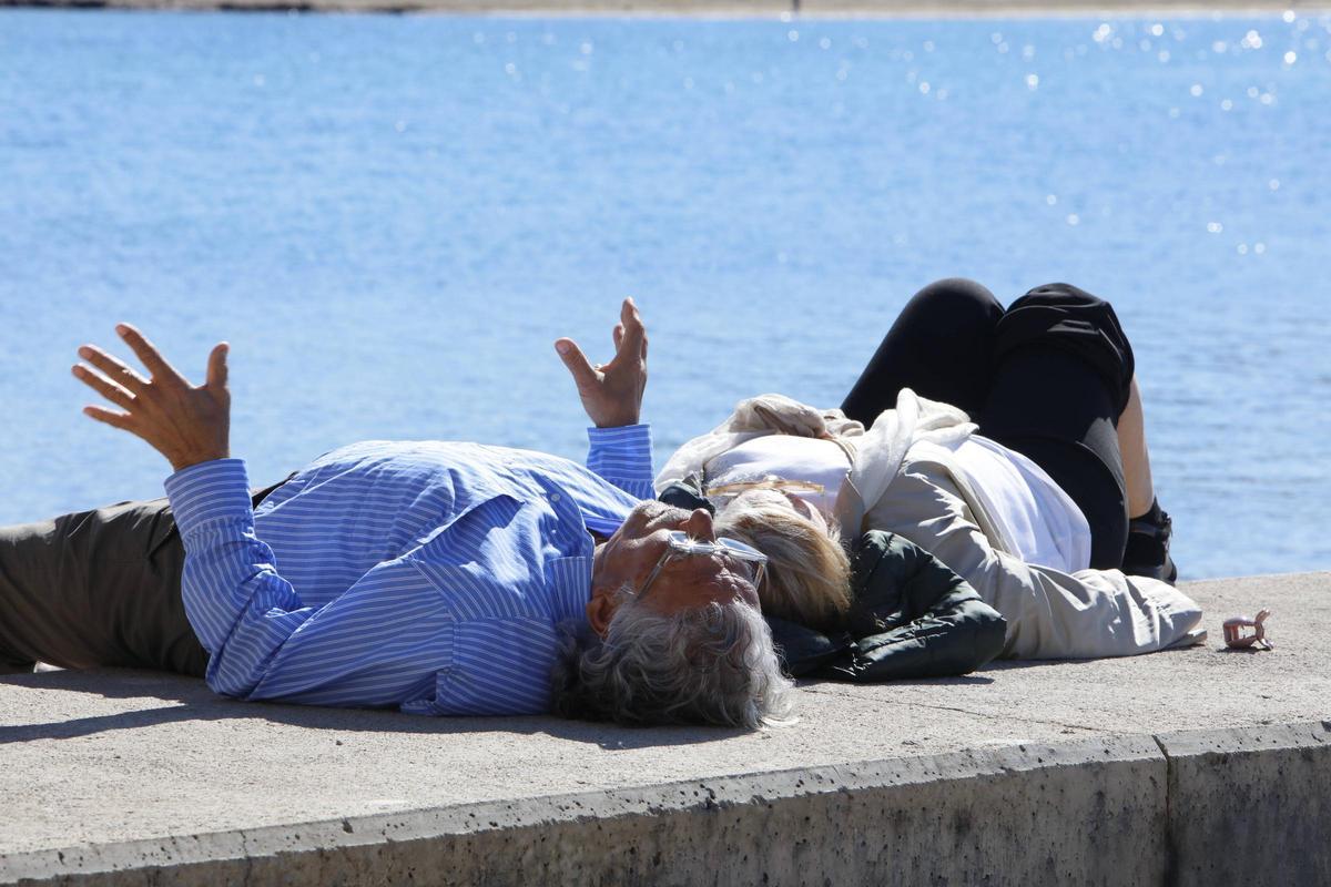 Urlauber tanken Sonne am Strand von Santa Ponça.