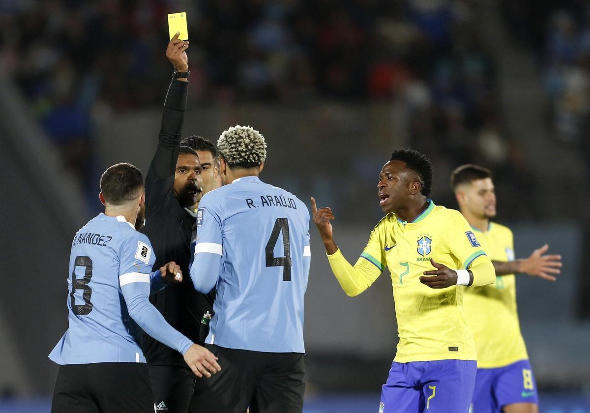 Vinicius increpa al árbitro y a Araujo cuando el defensa uruguayo es amonestado.