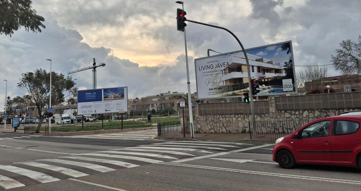 A la izquierda, el cartel de las viviendas de protección pública y, a la derecha, el de la nueva promoción de pisos "exclusivos"