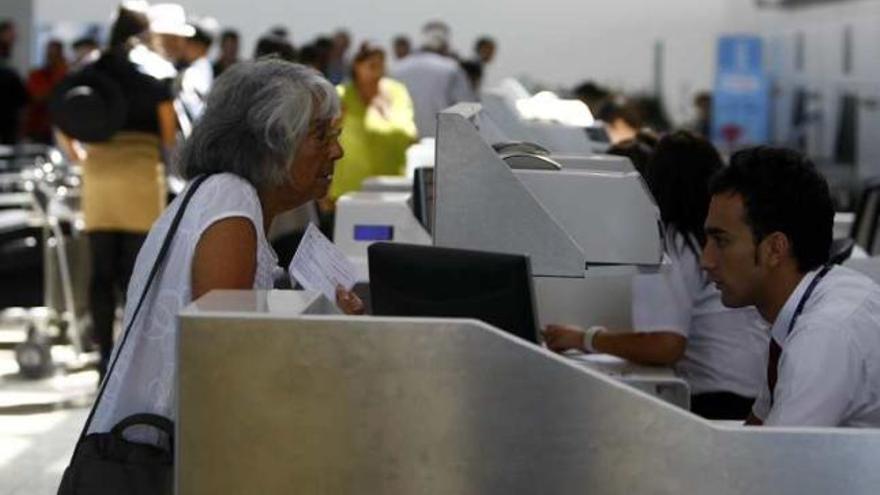 Una pasajera recoge su tarjeta de embarque en la terminal.