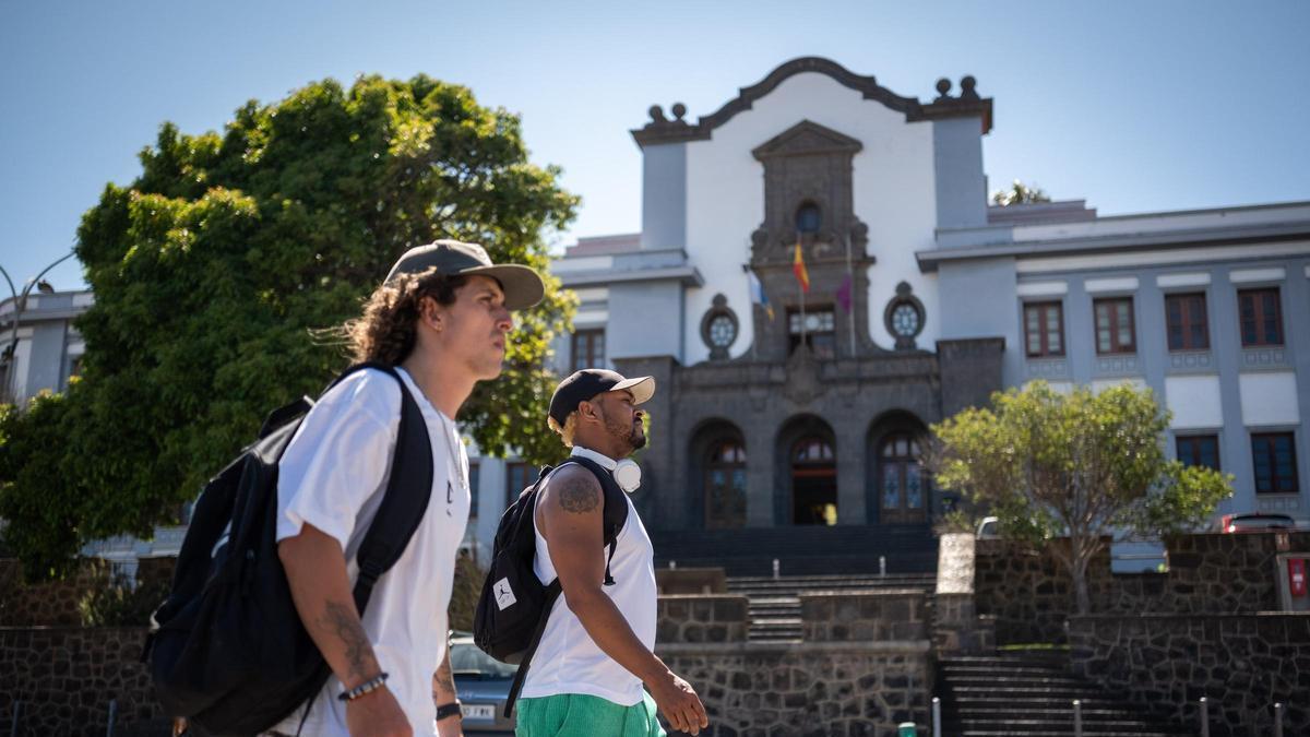 Dos estudiantes caminando delante del Edificio Central de la Universidad de La Laguna