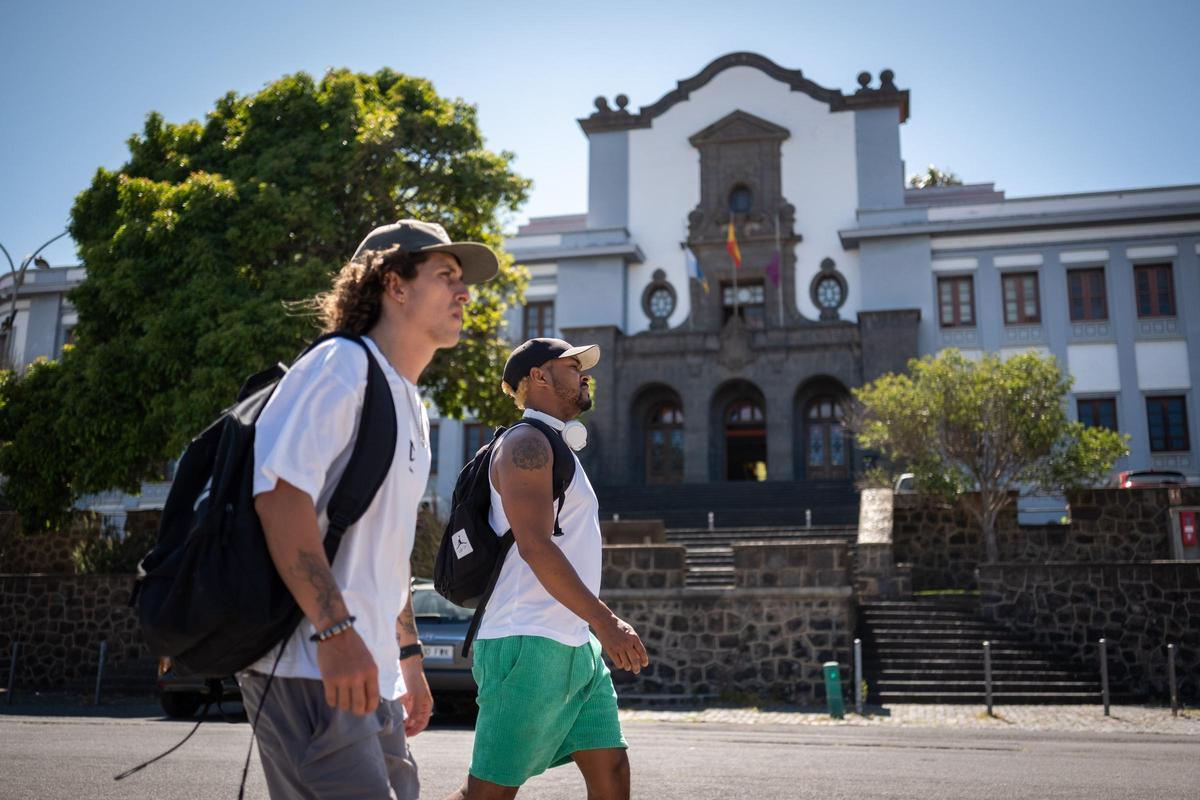 Dos estudiantes caminando delante del Edificio Central de la Universidad de La Laguna