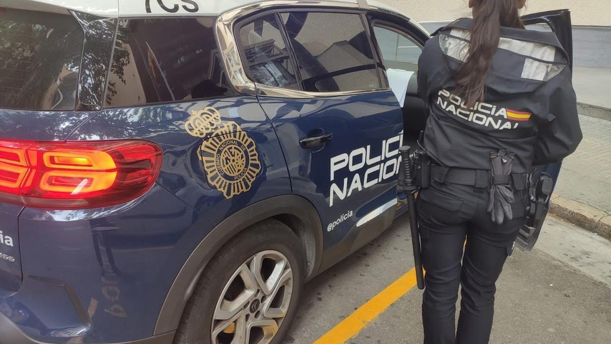 Un agente de la Policía Nacional entra en el coche patrulla.