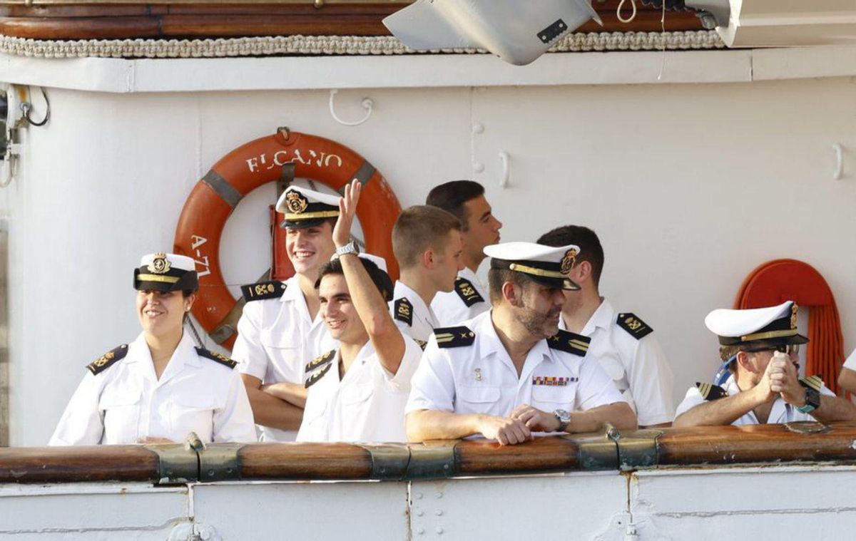 Algunos de los miembros de la tripulación del «Elcano» saludan a los congregados en el espigón II del puerto gijonés.