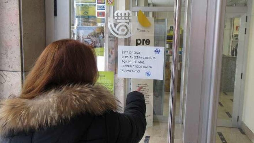 Una canguesa lee el cartel de Correos en Cangas de Onís.