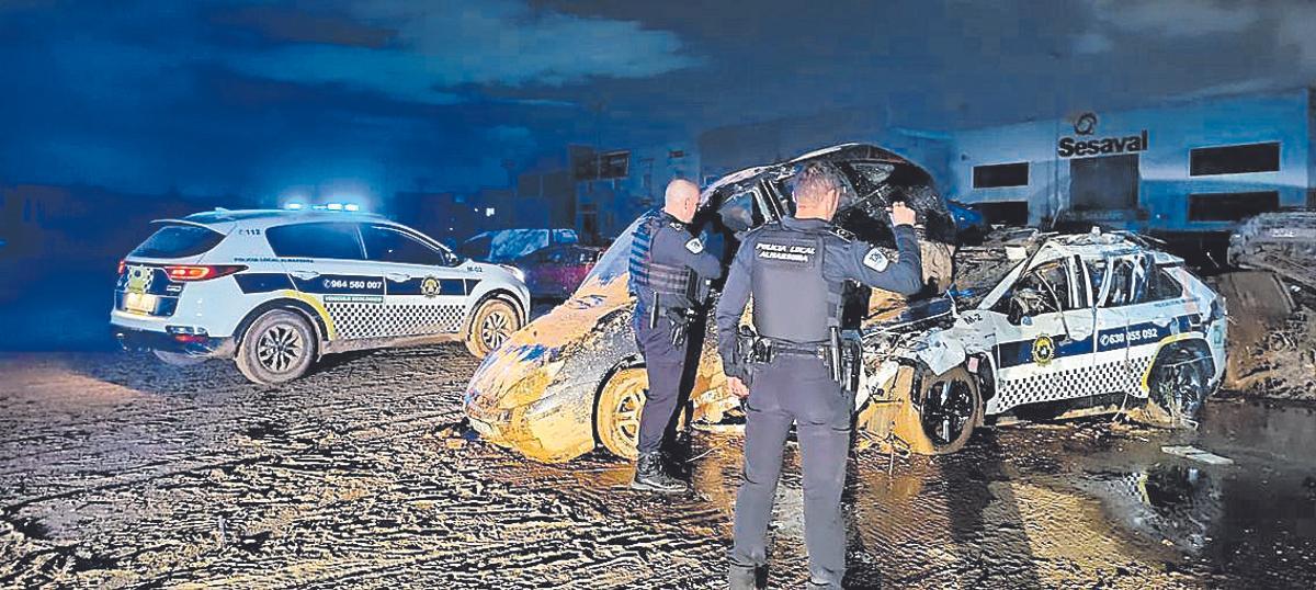 Dos agentes municipales de Almassora inspeccionan coches en Alfafar de madrugada.
