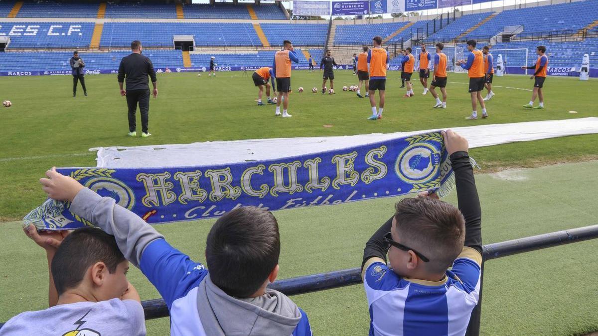 Un grupo de aficionados del Hércules, menores de edad, anima a la plantilla en un entrenamiento en Alicante.