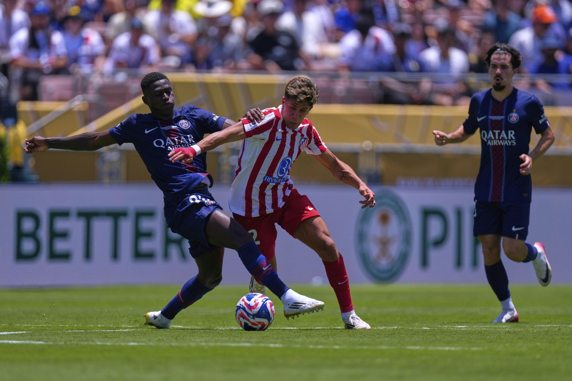 Paris Saint-Germain's Nuno Mendes, left, vies for the ball with Atletico Madrid's Giuliano Simeone during the Club World Cup group B soccer match between PSG and Atletico Madrid, in Pasadena, Calif., Sunday, June 15, 2025. (AP Photo/Mark J. Terrill)