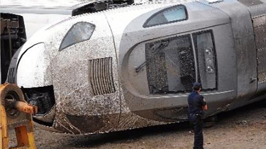 Un policia passa al costat de la part davantera del tren accidentat.