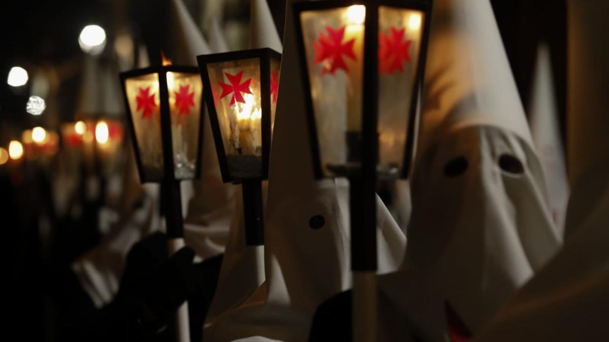 Asociados portan los faroles con los hachones durante el desfile procesional