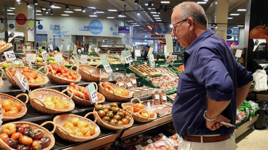 Un home compara els preus de la verdura en un supermercat de Barcelona