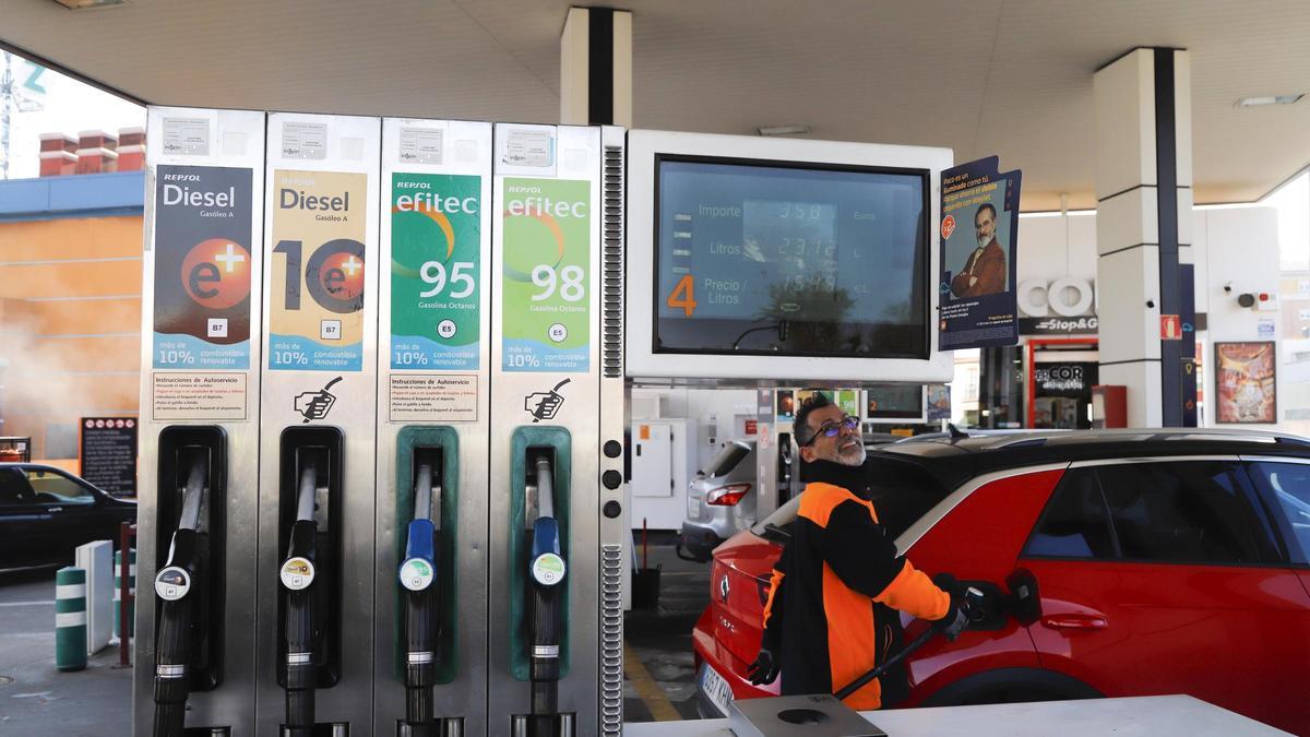 Un profesional sirve carburante a un cliente en una gasolinera.