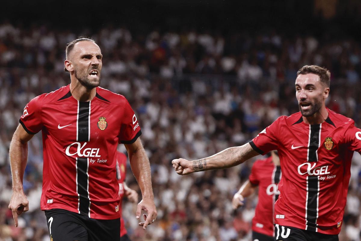El delantero kosovar del Mallorca Vedat Muriqi (i) celebra su gol durante el partido de la tercera jornada de LaLiga entre el Real Madrid y el RCD Mallorca, este sábado en el estadio Santiago Bernabéu. EFE/Sergio Pérez. (Real Madrid) (Mallorca)