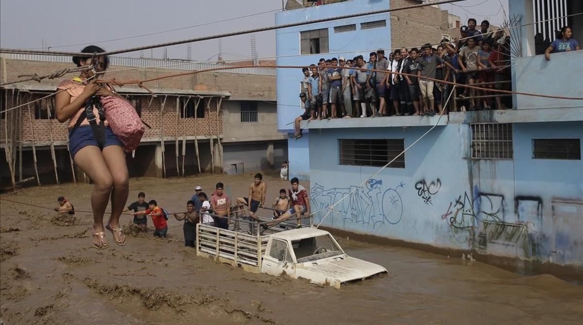 jjubierre37708744 a woman is pulled high over flood waters in a zip line harne170321192412