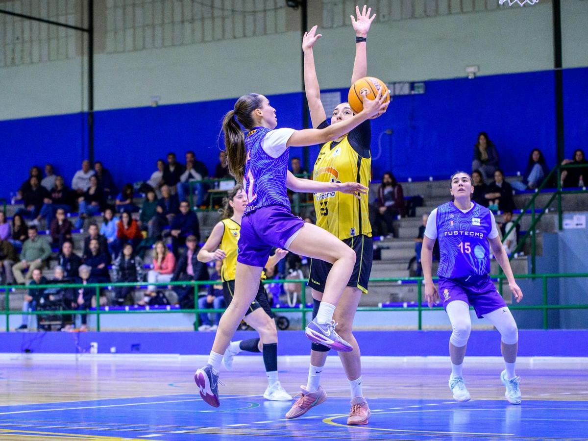 Una jugadora local entra a canasta.