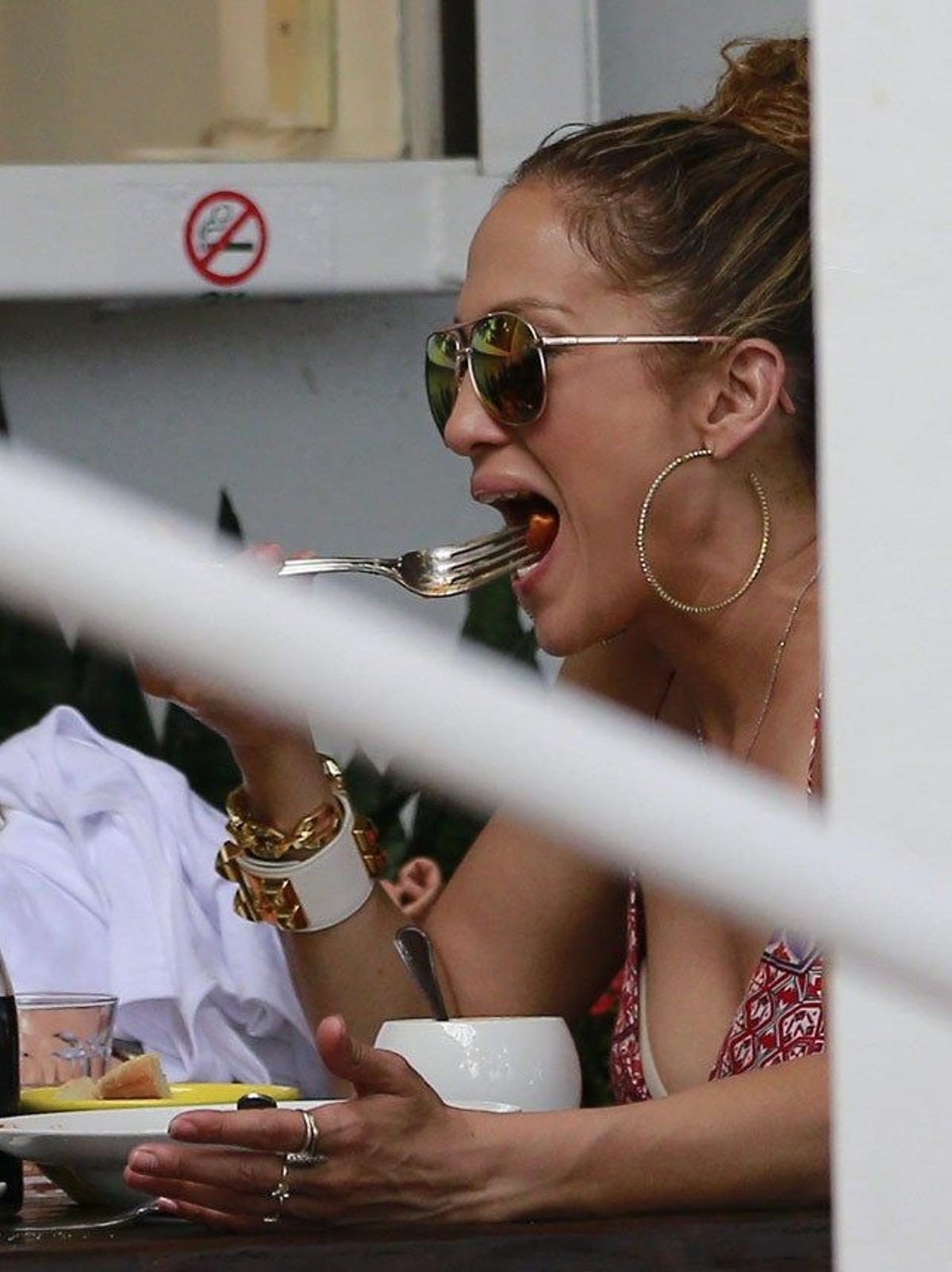 Jennifer Lopez llevándose comida a la boca