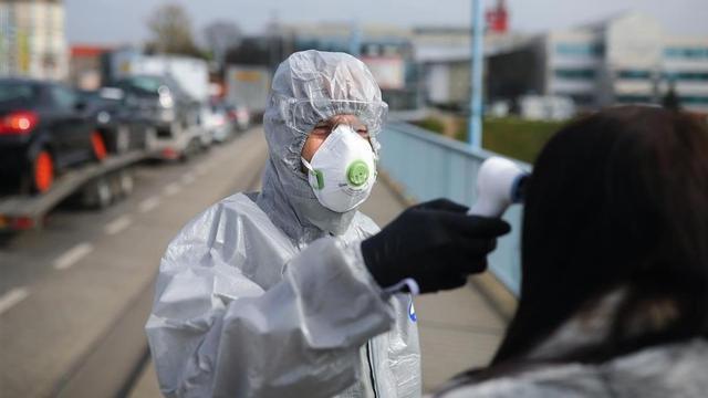 Un agente mide la temperatura a una mujer en un control por el coronavirus en la frontera entre Polonia y Alemania.