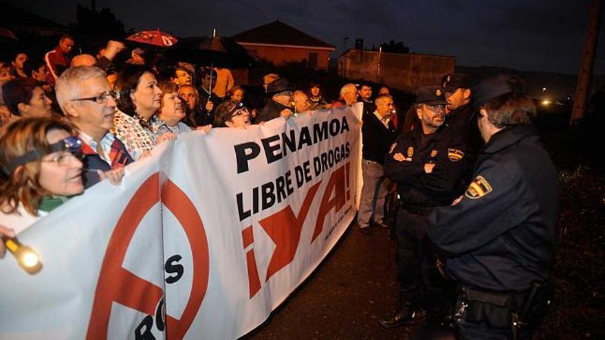 Manifestantes y policías, ayer, a la entrada del asentamiento chabolista de Penamoa. / juan varela