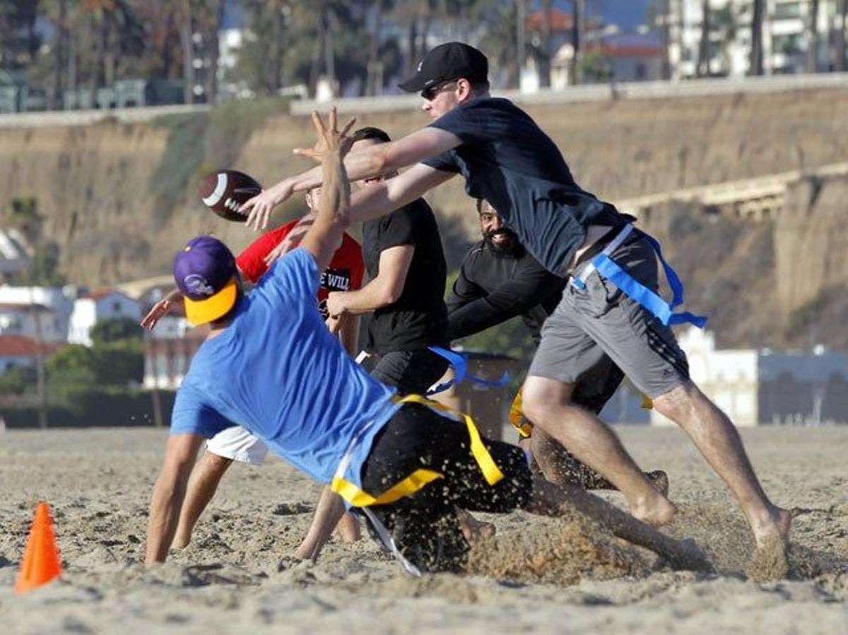 Josh Duhamel juega al fútbol americano con unos amigos en la playa