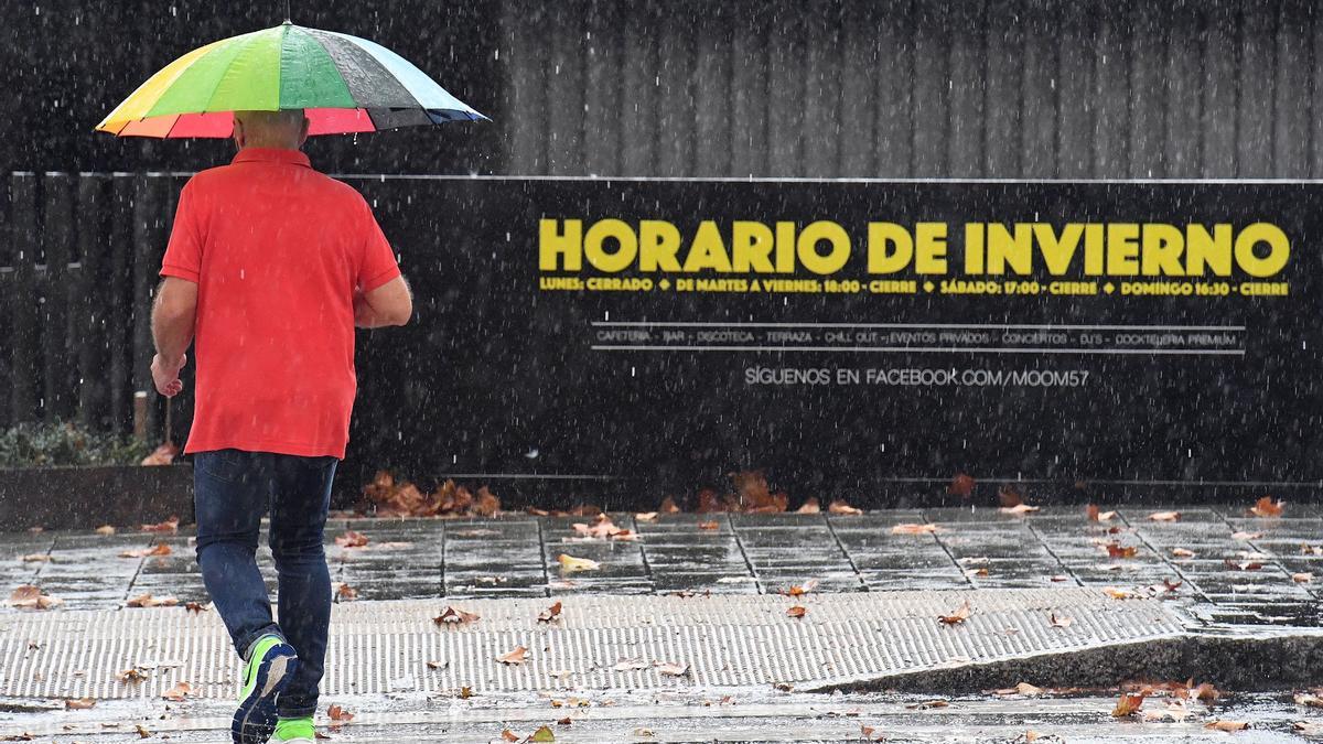 Un hombre con paraguas, en el paseo marítimo coruñés.