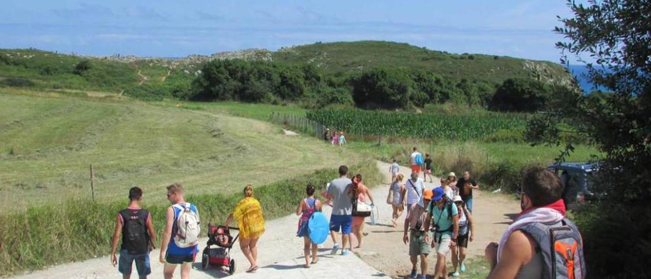 Varios turistas caminando hacia el arenal ayer. emilio g. cea