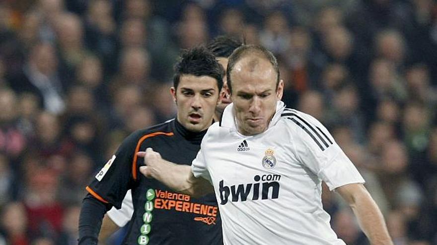 El centrocampista holandés del Real Madrid Arjen Robben y el delanero del Valencia David Villa disputan un balón durante el partido, correspondiente a la decimosexta jornada de Liga de Primera División, disputado esta tarde en el estadio Santiago Bernabéu.
