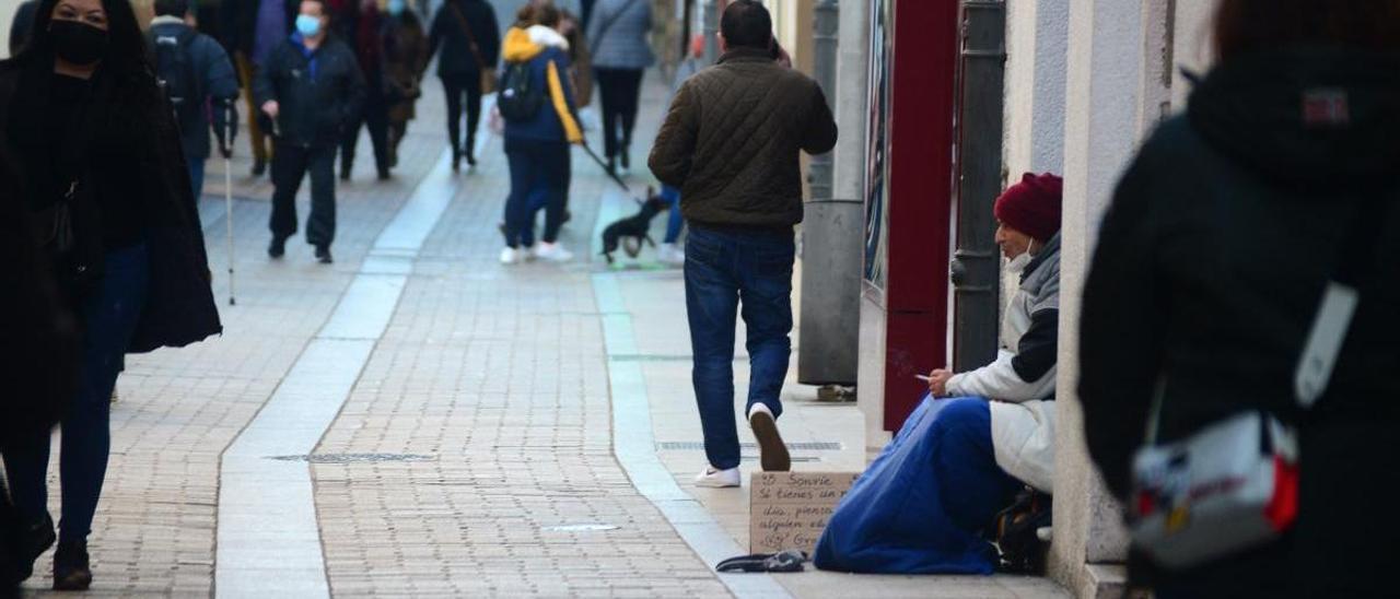 Una persona pidiendo en la calle en Plasencia, que habilitará duchas para las personas sin hogar.