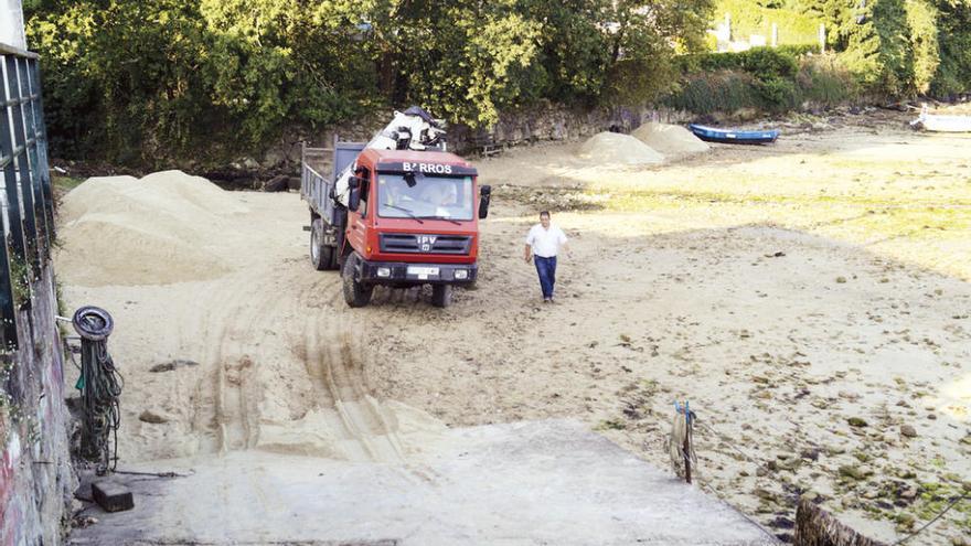 Un camión realiza las labores de reposición de la arena en la playa de Rande. // FdV