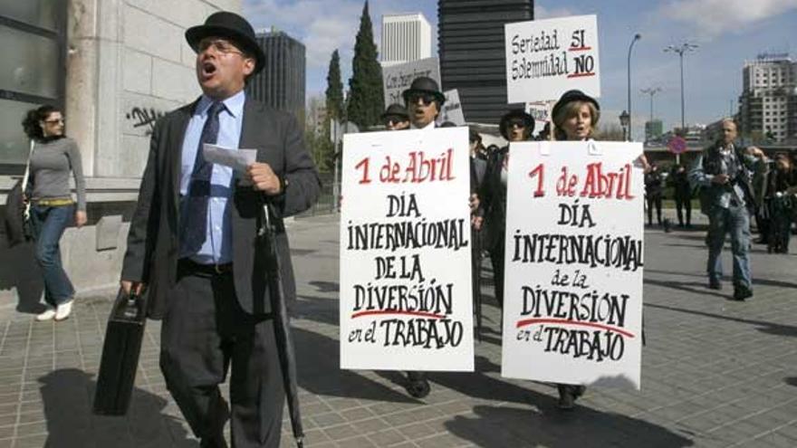 Varias personas vestidas con traje y bombín, durante la &quot;Primera Marcha por la Diversión en el Trabajo&quot;, que organizaron hoy por el Paseo de la Castellana de Madrid
