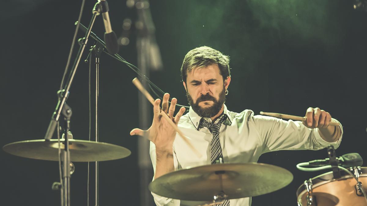 Cheka, tocant la bateria en un concert.