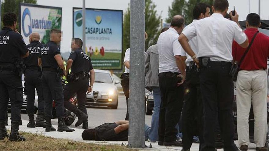 El joven conductor secuestrado por el detenido para huir, en el suelo tras interceptarse su coche. / nick