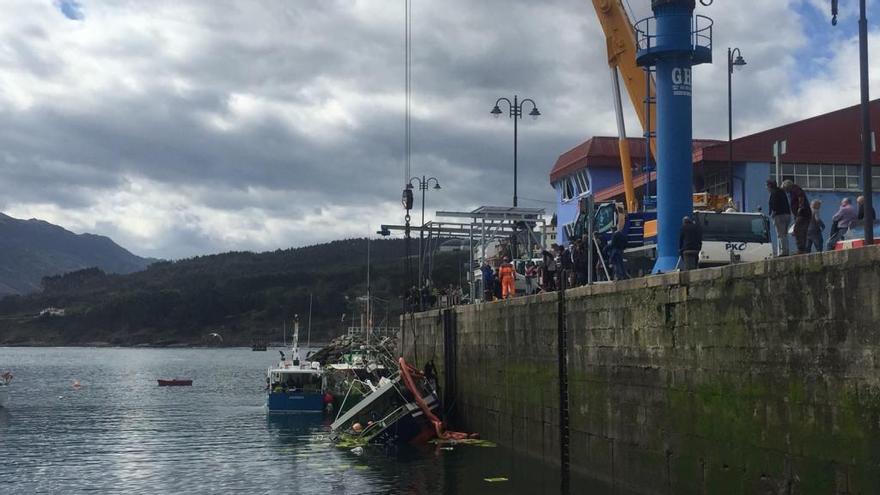 Tratan de sacar a flote el barco hundido con xarda en el puerto de Lastres