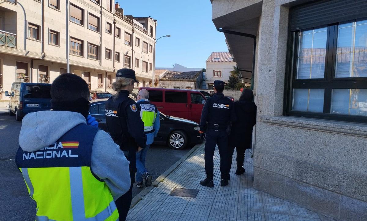 El detenido, a la derecha de la imagen, es custodiado por un agente de la Policía tras su detención. | A.M.