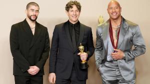 Jonathan Glazer (C) posa con Bad Bunny (L) y Dwayne Johnson (R) en la gala de los Oscar