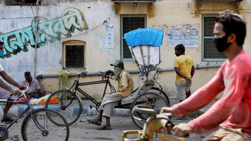 Ciclistas con mascarillas en Calcuta.