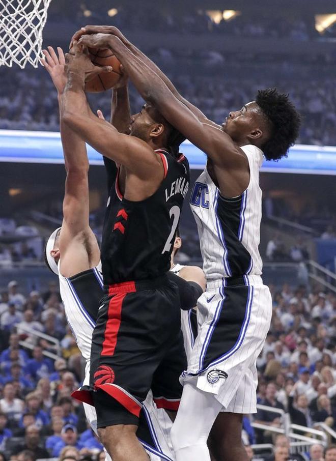 Jonathan Isaac # 1 del Orlando Magic bloquea el disparo desde atrás de Kawhi Leonard # 2 de los Toronto Raptors durante el tercer juego de la primera ronda de los playoffs de la Conferencia Este de la NBA de 2019 en el Amway Center.