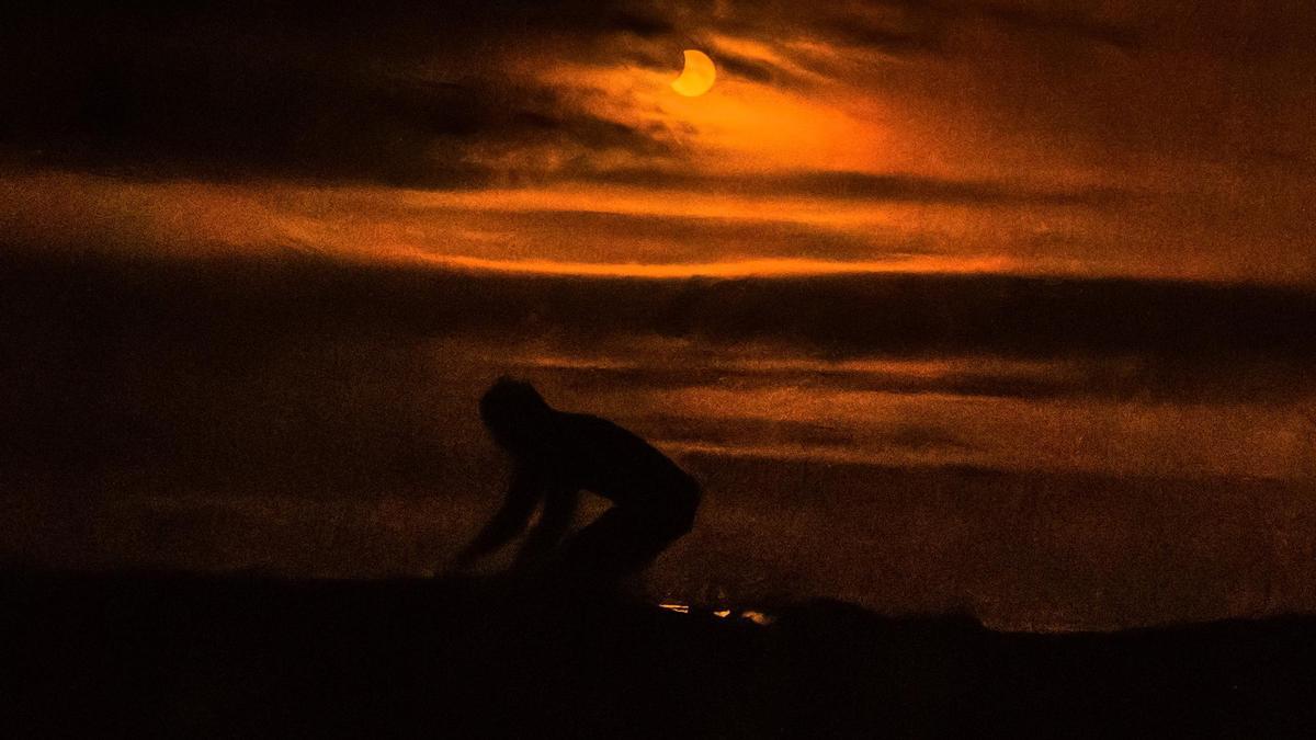 Una de las imágenes que tomó Pedro Gómez desde el agua, durante la segunda parcialidad del eclipse, con Guillermo Ocaña montado sobre la tabla de surf.