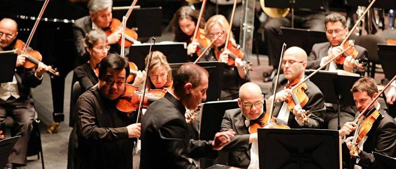 El violinista chino Ning Feng, a la izquierda, junto al director de la OSPA, Rossen Milanov, durante el concierto de ayer.