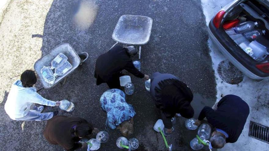 Vecinos de Castro de Alcañices llenan garrafas con el agua de un camión cisterna de la Diputación.