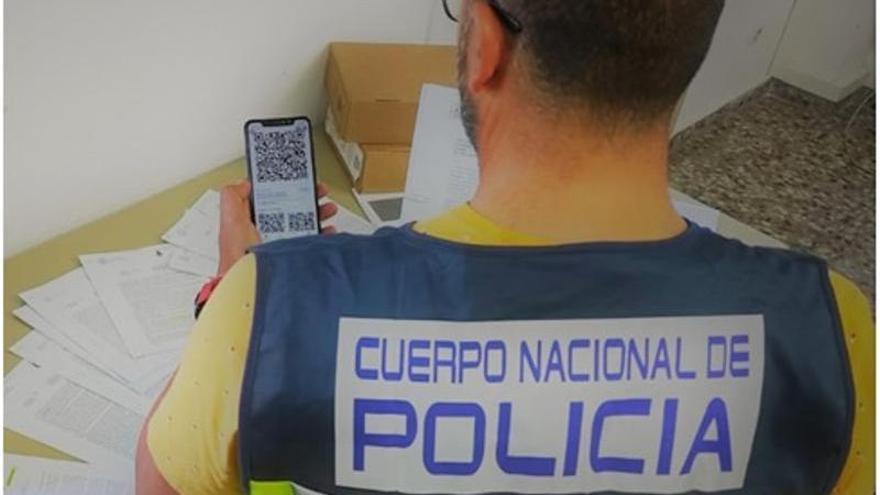 Un policía, con un móvil que muestra un código QR