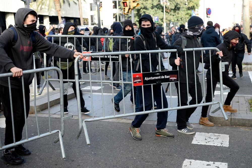 Protesters remove crowd control barricades during scuffles with police at a pro-independence demonstration in Barcelona on December 21, 2018 as the Spanish cabinet held a meeting in the city. - Catalan pro-independence groups blocked roads in the region to protest the meeting. The weekly cabinet meeting usually takes place in Madrid but the government decided to hold it in the Catalan capital as part of its efforts to reduce tensions in Catalonia, which last year made a failed attempt to break away from Spain. (Photo by Josep LAGO / AFP)