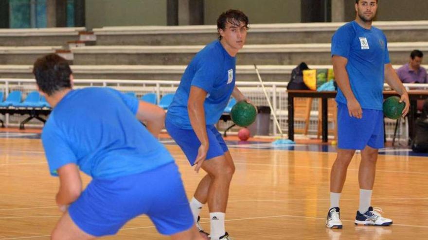 Víctor Rodríguez se dispone a pasar el balón ante la presencia de Borja Pedreira y otro compañero.