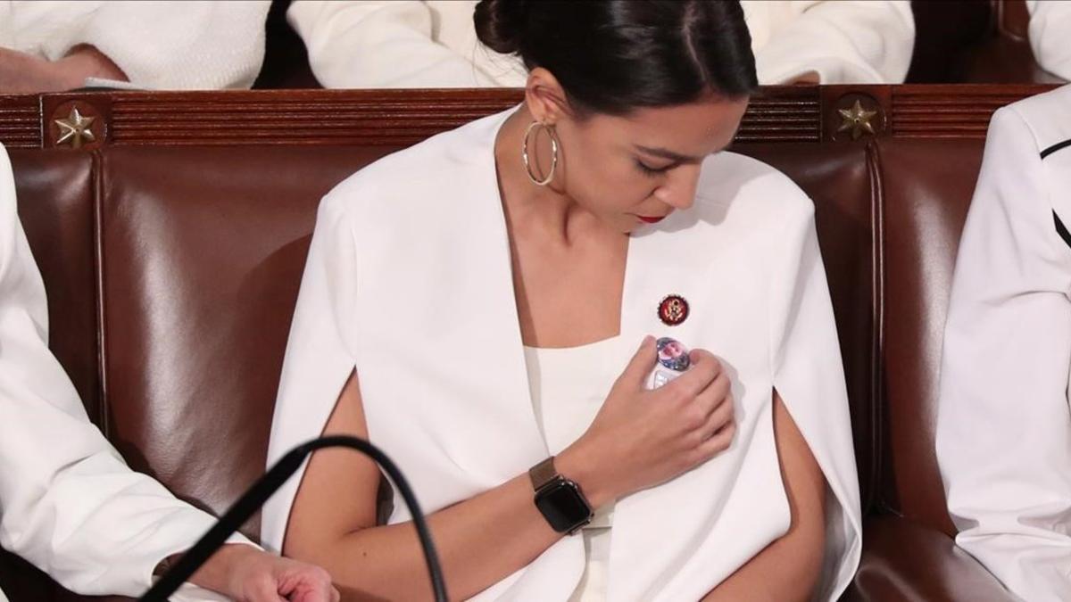 Alexandria Ocasio-Cortez coloca su pin.