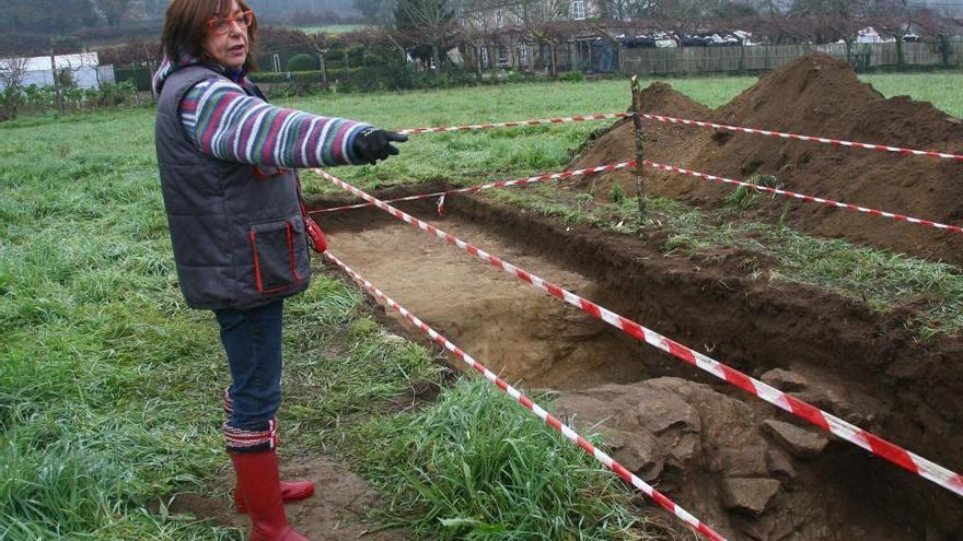 La arqueóloga directora de las catas encargadas por Fomento, junto a la estructura pétrea localizada en la cata S1. // Bernabé / Adrián Rei