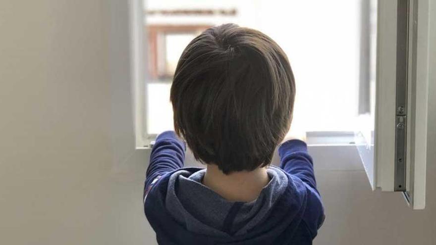 Un niño de cinco años mira por la ventana de su casa en Madrid, de la que no sale desde el pasado 11 de marzo.