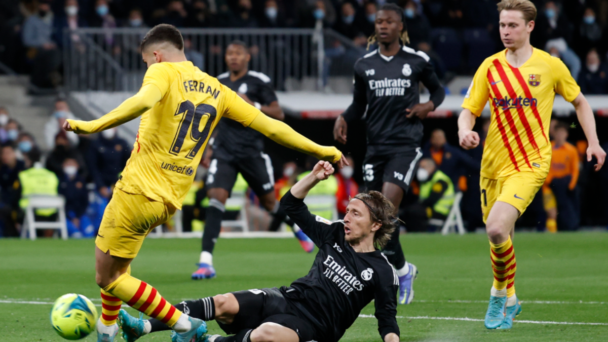 Modric trata de frenar un disparo de Ferran Torres.