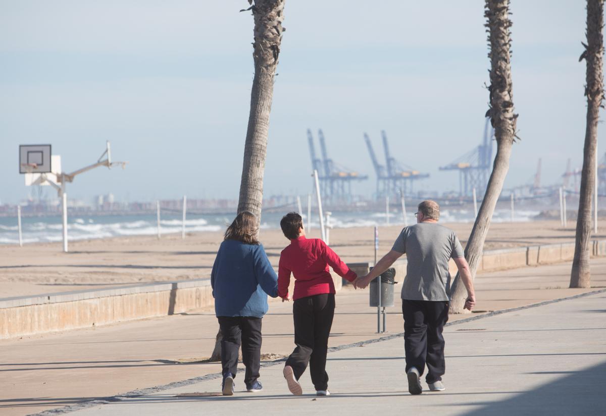 Imagen de archivo de una familia paseando pro al playa.