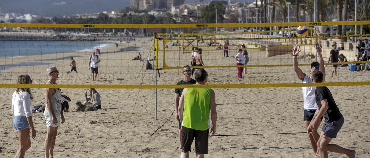 Unos jóvenes aprovechan el buen tiempo para jugar a voley en la playa de Can Pere Antoni, en Palma