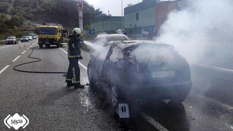 Los bomberos extinguen el fuego de un vehículo en llamas en la AS-117