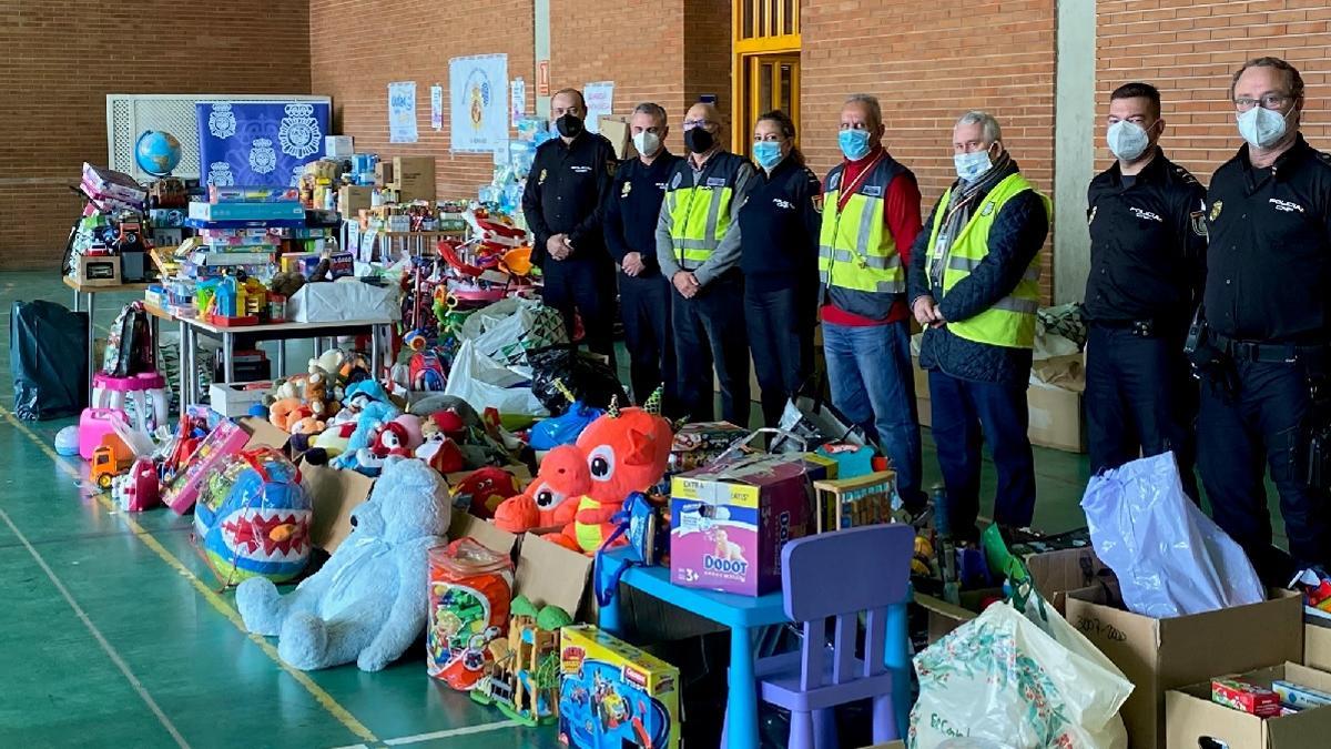 Agentes de la Policía Nacional y miembros de La Biznaga Azul, con lo recaudado en la campaña navideña.